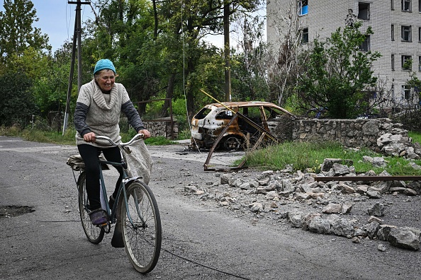 Une femme circule à vélo dans le village récemment libéré de Vysokopillya, dans la région de Kherson, le 27 septembre 2022. Photo Genya SAVILOV/AFP via Getty Images.
