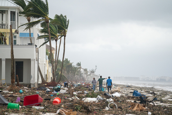 Des personnes marchent le long de la plage en regardant les biens endommagés par l'ouragan Ian, le 29 septembre 2022 à Bonita Springs, en Floride. (Photo : Sean Rayford/Getty Images)