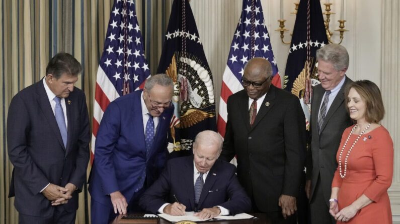 Le président Joe Biden signe la loi sur la réduction de l'inflation sous le regard de parlementaires démocrates à la Maison Blanche, le 16 août 2022. (Drew Angerer/Getty Images)