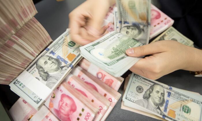 Décompte de billets de 100 yuans et dollars américains, au guichet d'une banque à Nantong, dans la province chinoise du Jiangsu (est), le 6 août 2019. (STR/AFP via Getty Images)