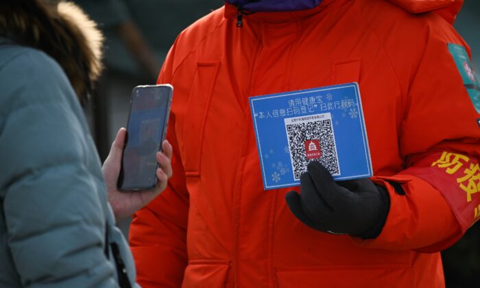 Contrôle d’un code santé effectué au moyen d’un téléphone portable à l’entrée d’une patinoire non loin de Pékin, le 12 janvier 2021. (Wang Zhao/AFP via Getty Images)