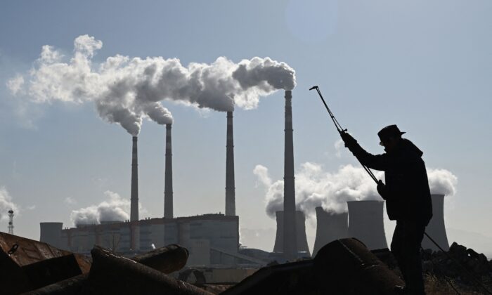 Un ouvrier en train de couper des tuyaux en acier près de la centrale électrique Datang International Zhangjiakou, alimentée au charbon, le 12 novembre 2021. (Greg Baker/AFP via Getty Images)