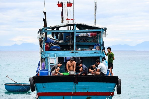 Des pêcheurs travaillent à bord de leur bateau près de l'île au large de Ly Son au Vietnam, le 20 août 2022. Photo de NHAC NGUYEN/AFP via Getty Images.