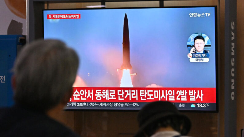 Des personnes regardent un écran de télévision montrant une émission d'informations avec des images d'archives d'un essai de missile nord-coréen, dans une gare ferroviaire de Séoul, le 28 septembre 2022. (Photo by JUNG YEON-JE/AFP via Getty Images)