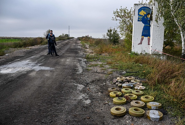 Des membres d'une unité ukrainienne de déminage se tiennent près de mines antichars récupérées et désarmées près d'Izyum, dans l'est de l'Ukraine, le 1er octobre 2022. Photo de Juan BARRETO / AFP via Getty Images.