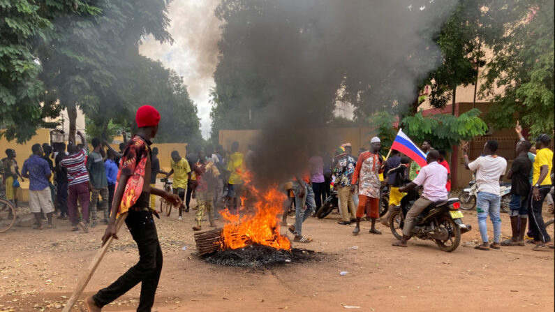 Des manifestants se rassemblent devant l'ambassade de France à Ouagadougou le 2 octobre 2022 autour des restes d'un pneu en feu. (Photo by -/AFP via Getty Images)