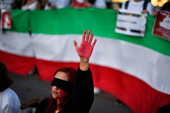 Une femme lève sa main avec de la peinture rouge lors d'une manifestation de soutien aux femmes iraniennes, le 4 octobre 2022 à Barcelone, suite à la mort de l'Iranienne kurde Mahsa Amini en Iran. (Photo : PAU BARRENA/AFP via Getty Images)