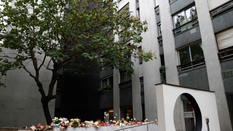 Cette photo prise à Paris le 17 octobre 2022 montre des bouquets de fleurs exposés à l'entrée de l'immeuble où vivait Lola, une adolescente de 12 ans retrouvée morte dans une malle dans le 19e arrondissement le 14 octobre 2022. (Photo by GEOFFROY VAN DER HASSELT/AFP via Getty Images)