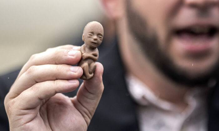 Fœtus en plastique montré par un militant pro-vie lors d'une manifestation devant la Cour suprême des États-Unis à Washington, le 23 juin 2022. (Nathan Howard/Getty Images)