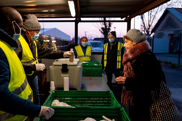 Des membres du personnel du Secours Catholique distribuent un petit-déjeuner aux sans-abri et aux personnes dans le besoin à Toulouse. (Photo : LIONEL BONAVENTURE/AFP via Getty Images)