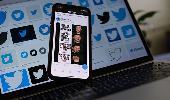 Sur cette photo d'illustration, la page Twitter d'Elon Musk s'affiche sur l'écran d'un smartphone avec des logos Twitter en arrière-plan. (Photo : CHRIS DELMAS/AFP via Getty Images)