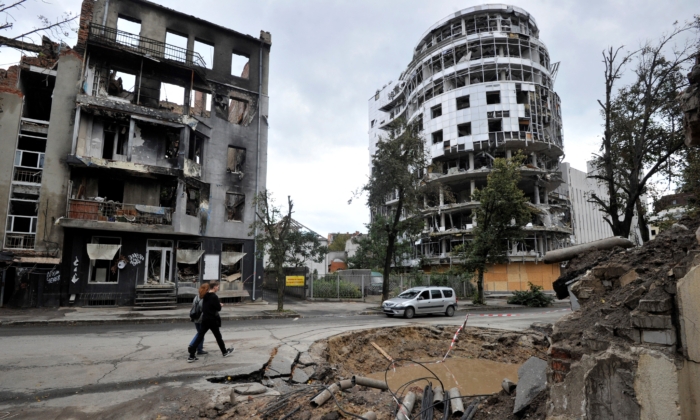 Des gens passent devant un bâtiment détruit à la suite d'un bombardement dans le centre de Kharkiv, en Ukraine, le 18 septembre 2022. (Sergei Chuzavkov/AFP via Getty Images)