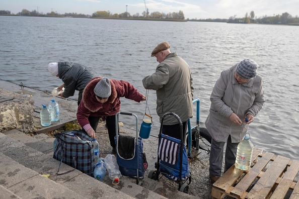 Les gens prennent l'eau du fleuve Dniepr pour l'utiliser au nettoyage, à Kherson, le 14 novembre 2022. Photo de BULENT KILIC/AFP via Getty Images.