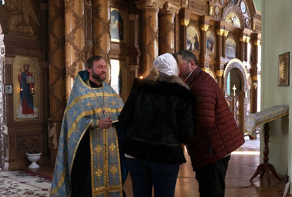 Un prêtre orthodoxe organise une cérémonie de mariage pour les résidents locaux, Andrey et Natalya, à la cathédrale Sainte-Catherine de la ville reprise de Kherson le 14 novembre 2022. Photo par ANATOLII STEPANOV/AFP via Getty Images.
