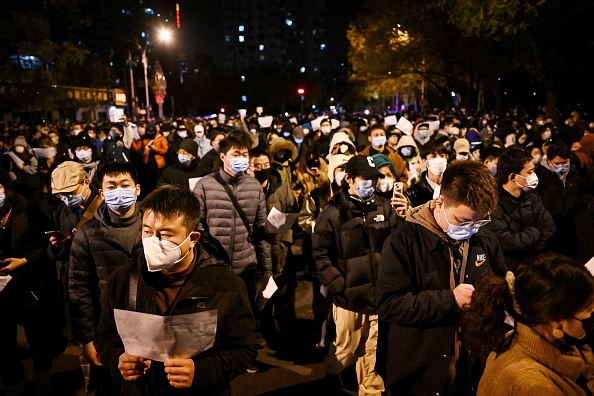 Des manifestants défilent dans une rue lors d'un rassemblement pour les victimes d'un incendie meurtrier et pour protester contre les restrictions sévères imposées par la Chine en matière de Covid-19, à Pékin, le 28 novembre 2022. (Photo: NOEL CELIS/AFP via Getty Images)
