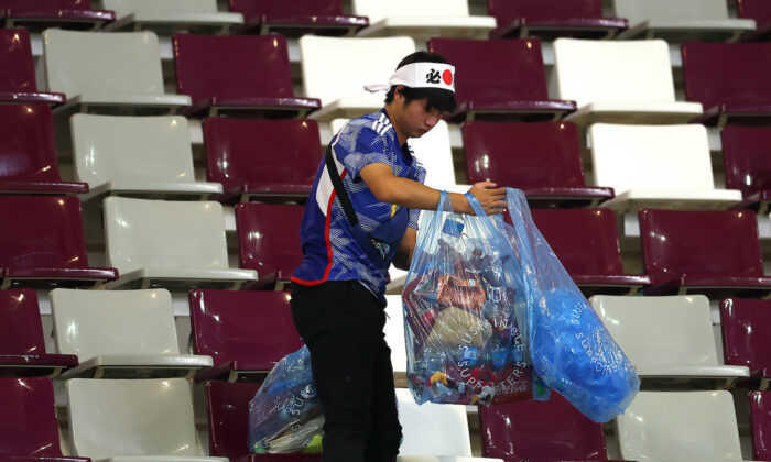 Un supporter japonais nettoie les tribunes des déchets après le match de la Coupe du monde de football 2022 entre l'Allemagne et le Japon à Doha, au Qatar, le 23 novembre 2022. (Alex Grimm/Getty Images)