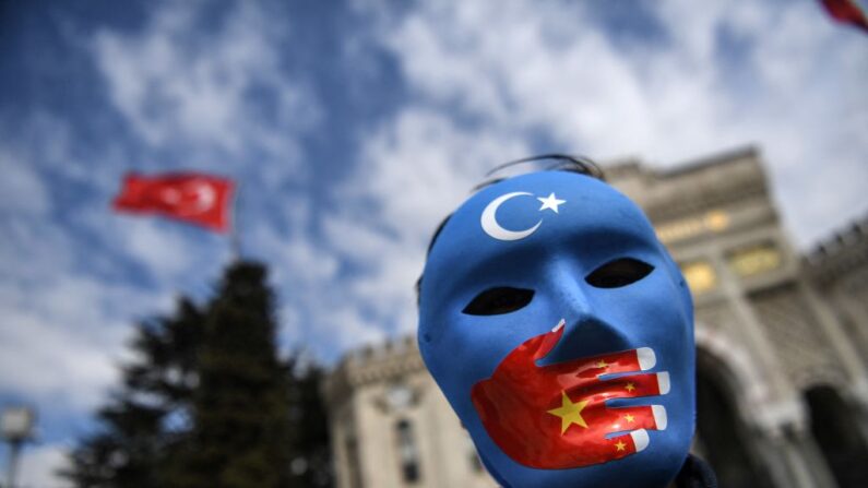 Manifestant portant un masque peint aux couleurs du drapeau du Turkestan oriental sur la place Bayazit à Istanbul, le 1er avril 2021. (Ozan Kose/AFP via Getty Images)