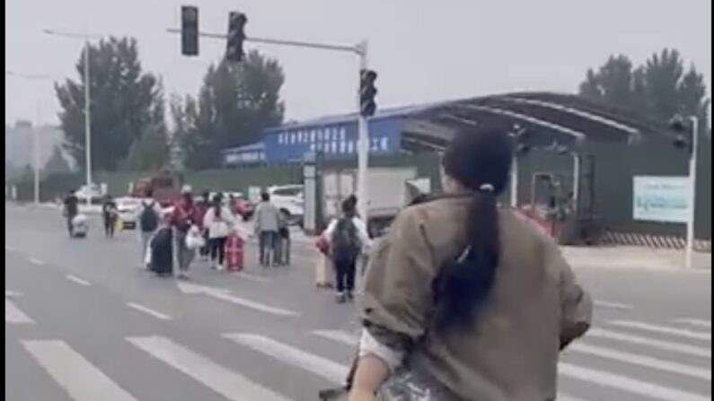 Une femme en train de fuir Zhengzhou valise en main sur une photo tirée d'une vidéo publiée sur les réseaux sociaux chinois le 29 octobre 2022.