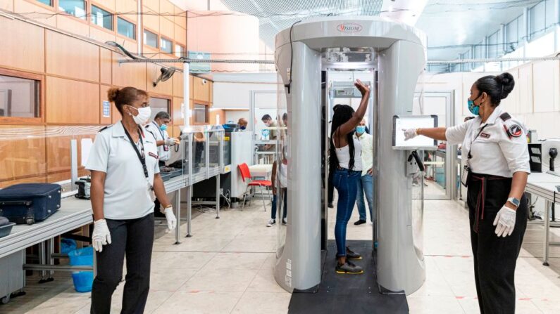 Une passagère passe dans un scanner à ondes millimétriques pour vérifier la présence de produits de contrebande à un poste de contrôle de sécurité de l'aéroport Félix-Éboué, le 17 juin 2020. (Photo: JODY AMIET/AFP via Getty Images)