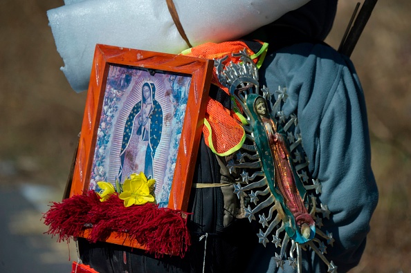 Un pèlerin porte des images de la Vierge de Guadalupe en marchant à Santiago Xalitzintla, Puebla, Mexique, sur le chemin de la Basilique de Guadalupe à Mexico. (Photo : CLAUDIO CRUZ/AFP via Getty Images)