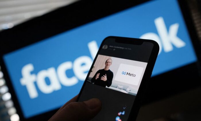 Sur cette photo d'illustration prise à Los Angeles le 28 octobre 2021, une personne regarde sur un smartphone le PDG de Facebook, Mark Zuckerberg, dévoiler le logo META. (Chris Delmas/AFP via Getty Images)