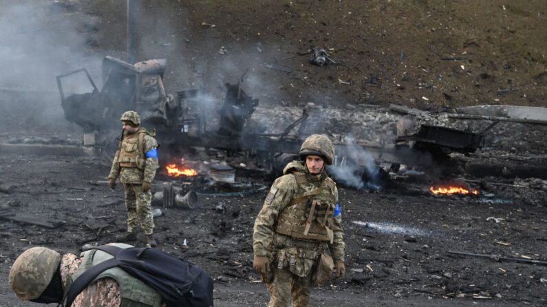 Des soldats ukrainiens cherchent et ramassent des obus non explosés après un combat avec un groupe de raiders russes dans la capitale ukrainienne de Kyiv, le 26 février 2022.  (Photo : SERGEI SUPINSKY/AFP via Getty Images)