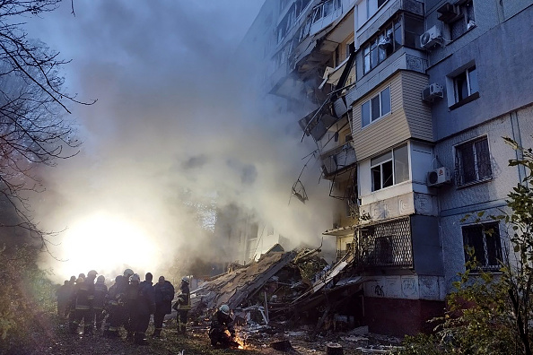 Des sauveteurs se rassemblent devant un immeuble résidentiel endommagé après une frappe sur la ville ukrainienne de Zaporijjia, le 9 octobre 2022. (MARYNA MOISEYENKO/AFP via Getty Images)
