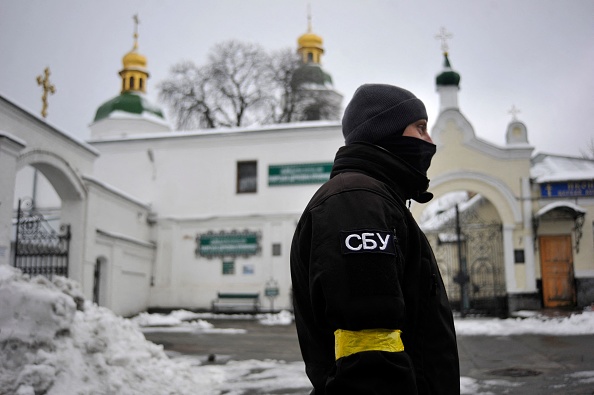 Un agent du Service de sécurité de l'Ukraine (SBU) se tient devant l'entrée du monastère Pechersk Lavra à Kiev. (Photo : SERGEI CHUZAVKOV/AFP via Getty Images)