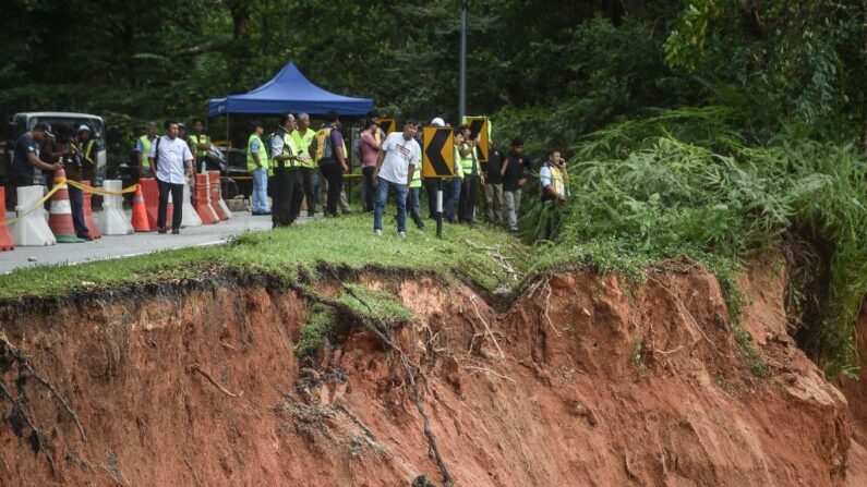 Des personnes inspectent les dégâts après un glissement de terrain à Batang Kali, le 16 décembre 2022. (Photo: ARIF KARTONO/AFP via Getty Images)
