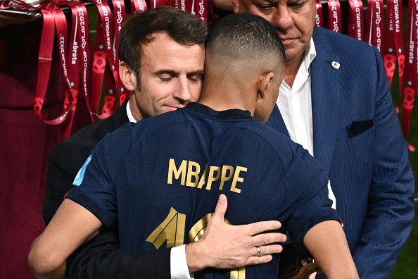 Le Président français Emmanuel Macron console l'attaquant français n°10 Kylian Mbappé à la fin du match de la finale de la Coupe du monde de football Qatar 2022 entre l'Argentine et la France, le 18 décembre 2022. (Photo : JEWEL SAMAD/AFP via Getty Images)