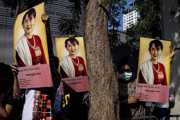 Des manifestants birmans brandissent des photos de la dirigeante civile du Myanmar, Aung San Suu Kyi, détenue, lors d'une manifestation devant l'ambassade du Myanmar à Bangkok, le 19 décembre 2022. (Photo JACK TAYLOR/AFP via Getty Images)