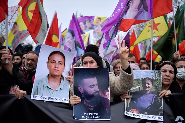  Des personnes de la communauté kurde tiennent les portraits des victimes Emine Kara et Mir Perwer lors d'une manifestation organisée Place de la République à Paris le 24 décembre 2022. (Photo : JULIEN DE ROSA/AFP via Getty Images)