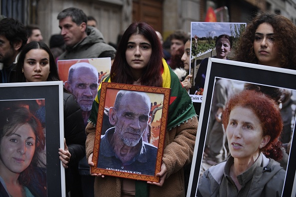 Portraits des victimes de la fusillade de la rue Enghien à Paris, le 23 décembre 2022, et ceux des meurtres de la rue La Fayette en 2013, alors qu'ils participent à une marche pour leur rendre hommage et en solidarité avec la communauté kurde à Paris, le 26 décembre 2022. (Photo : JULIEN DE ROSA/AFP via Getty Images)