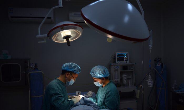 Cette photo prise le 9 août 2013 montre un chirurgien plastique L) effectuant une opération "spéciale" du nez sur un patient dans sa clinique de la ville de Chongqing, dans le sud-ouest de la Chine. Peter Parks/AFP/Getty Images)