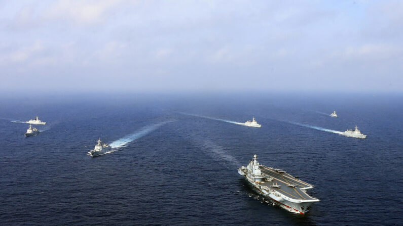Le porte-avions chinois, le Liaoning, navigue avec d'autres navires lors d'un "exercice de combat réel" en mer de Chine orientale, le 23 avril 2018. Une démonstration de force de la marine chinoise en plein essor dans des eaux contestées qui ont indisposé les pays voisins. (AFP via Getty Images) 