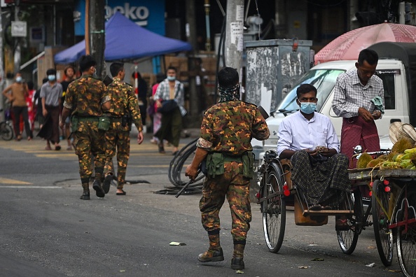 Des soldats marchent dans une rue, dans le centre-ville de Yangon. (Photo: STR/AFP via Getty Images)