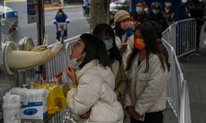 Un agent de santé prélève un échantillon par écouvillonnage sur une femme pour tester le coronavirus Covid-19 dans le quartier de Jing'an à Shanghai, le 7 décembre 2022. (Hector Retamal / AFP via Getty Images)