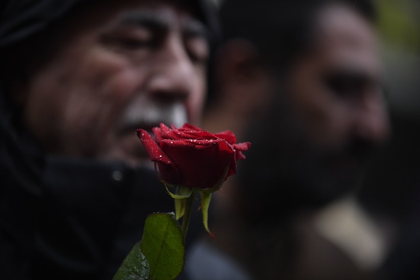 Un manifestant tient une rose en hommage aux victimes de la fusillade lors d'une marche de solidarité avec la communauté kurde à Paris le 26 décembre 2022. (Photo: JULIEN DE ROSA/AFP via Getty Images)