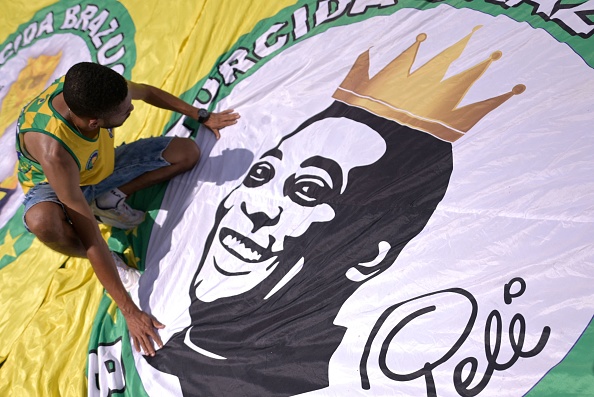 Un fan rend hommage à Pelé devant une réplique de la maison où il est né, selon les souvenirs de sa mère, Celeste Arantes, à Tres Coracoes, dans l'État du Minas Gerais, au Brésil, le 30 décembre 2022. (Photo: DOUGLAS MAGNO/AFP via Getty Images)