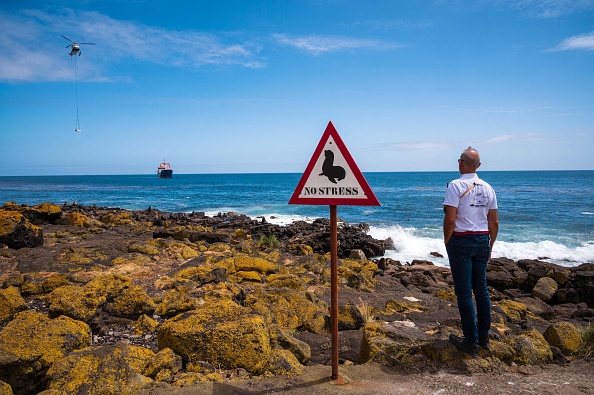 Le chef du district d'Amsterdam Jean-Philippe Branne regardant un transfert de fret du navire polyvalent "Marion Dufresne" par un hélicoptère, sur l'île Amsterdam, qui fait partie des Terres australes et antarctiques françaises dans l'océan Indien. (Photo: PATRICK HERTZOG/AFP via Getty Images)