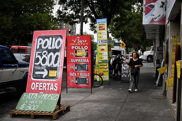 A woman walks between signs with food prices in the street in Buenos Aires on January 12, 2023. - Argentina registered inflation of 94.8 percent in 2022, its highest annual figure since 1991, the Indec national statistics institute said on Thursday. (Photo by Luis ROBAYO / AFP) Des panneaux indiquant les prix des produits alimentaires dans la rue, à Buenos Aires, le 12 janvier 2023. (Photo : LUIS ROBAYO/AFP via Getty Images)