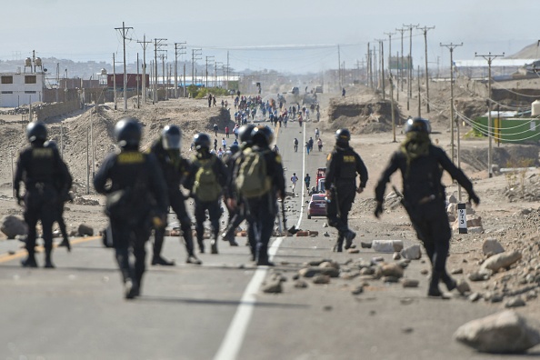 Des policiers patrouillent sur l'autoroute panaméricaine à La Joya alors que des manifestants tiennent un barrage pour demander la démission de la présidente péruvienne Dina Boluarte à Arequipa, au Pérou, le 12 janvier 2023. (Photo : DIEGO RAMOS/AFP via Getty Images)