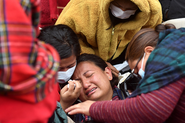 Des proches de victimes décédées dans le crash d'un avion de Yeti Airlines devant un hôpital de Pokhara, le 16 janvier 2023. (Photo : PRAKASH MATHEMA/AFP via Getty Images)
