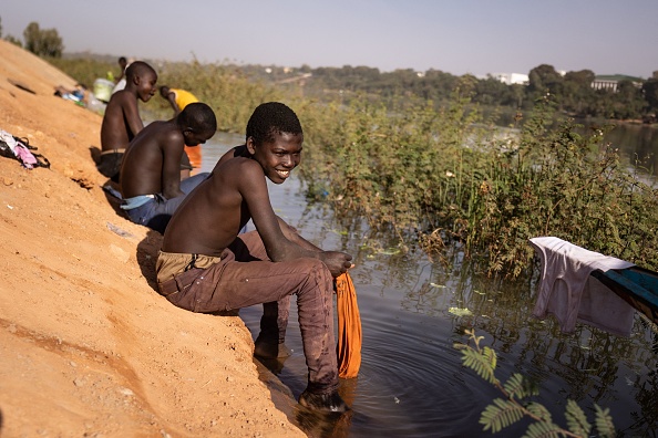 Des garçons lavent leurs vêtements dans le fleuve Niger à Niamey, le 27 janvier 2023. (Photo : OLYMPIA DE MAISMONT/AFP via Getty Images)