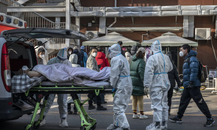 Un malade allongé sur une civière arrive dans un centre de traitement des cas fébriles à Pékin, le 9 décembre 2022. (Kevin Frayer/Getty Images)