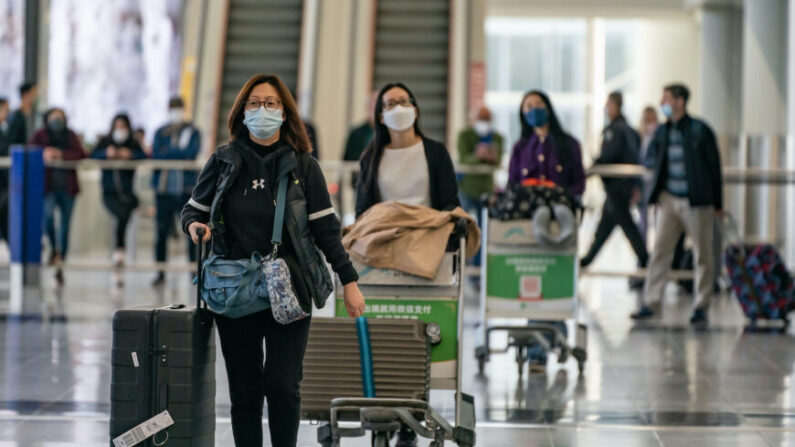 Des voyageurs marchent avec leurs bagages dans le hall d'arrivée de l'aéroport international de Hong Kong, le 30 décembre 2022. (Anthony Kwan/Getty Images)