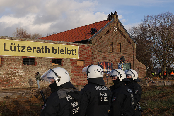 La police anti-émeute se tient à l'extérieur d'une ferme où des militants se sont barricadés à l'intérieur de la colonie de Luetzerath, le 11 janvier 2023, près d'Erkelenz, en Allemagne. (Photo: Sean Gallup/Getty Images)