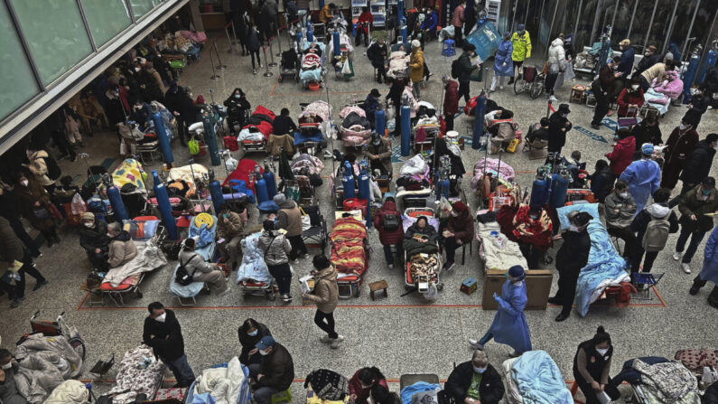 Des proches et le personnel médical s'occupent de patients sur des lits installés dans la cours intérieure d'un hôpital débordé de Shanghai, le 13 janvier 2023. (Kevin Frayer/Getty Images)