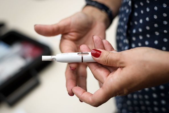 le tabac à chauffer du cigarettier Philip Morris, Iqos est "massivement promu" en illégalité. (FABRICE COFFRINI/AFP via Getty Images)