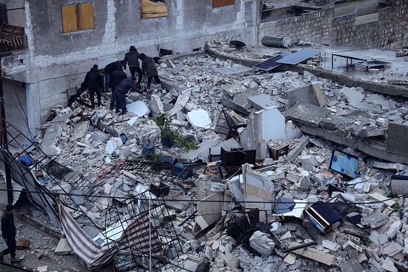 Recherches des victimes et des survivants parmi les décombres d'un bâtiment qui s'est effondré, en Syrie, tôt le 6 février 2023. (Photo : OMAR HAJ KADOUR/AFP via Getty Images)